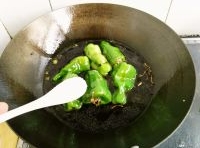 超過放入青椒，中火煎至青椒表皮變色，炒鍋加入醬油、料酒、適量的白糖和開水。