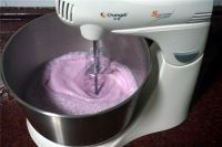 將冰淇淋液移到打蛋器盤子里，啟動打蛋器，攪拌10分鐘；