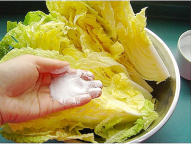 把鹽20克均勻的抹在白菜上，在上面壓上重物腌漬四小時；