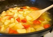 胡蘿蔔、土豆塊放進去煸炒，加點牛肉湯煮沸；