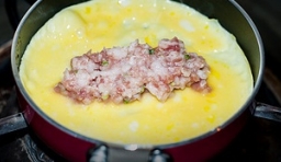 平底鍋用刷了抹少許油，倒入拌均勻的蛋液，等到快凝固的時候放入肉餡；
