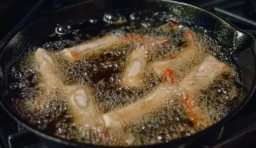把鍋中的火開大，鍋內的油溫度要達150℃，做好蝦仁春卷，炸至金黃色，大概2分鐘左右；