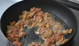 在炒鍋中加入適量的油燒熱，放入切好豬肉丁翻炒片刻，炒熟后盛入盤中；