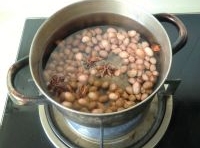 鍋里加清水燒開，把花生米和大料放進去煮熟；