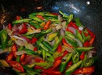 切好的小米辣、青椒放進去繼續炒加點豆瓣醬炒勻；