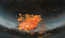  炒鍋燒熱,加入適量的油,侍油稍熱，放入豆瓣醬並炒出紅油； 
 