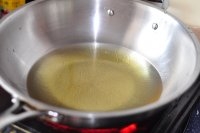 鍋中倒油燒熱，把拌好的菜糊用手擠成一個球狀放入油鍋里煎炸；