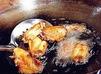 熱鍋中倒入適量的油，燒熱后，放入腌至好的雞翅炸至，變金黃色后，撈出；