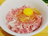 豬肉餡中，加入雞蛋、色拉油、料酒、醬油、十三香、鹽、雞精和薑末，用筷子攪拌均勻；
